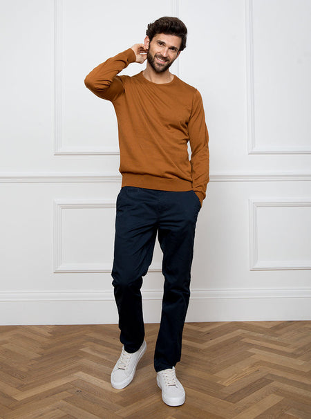 Man wearing ginger/burnt orange crewneck sweater knit in 100% luxury and premium merino wool.